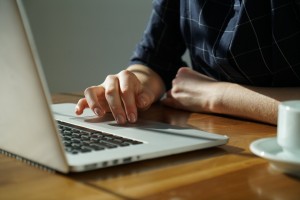 Woman uses touchpad mouse on laptop